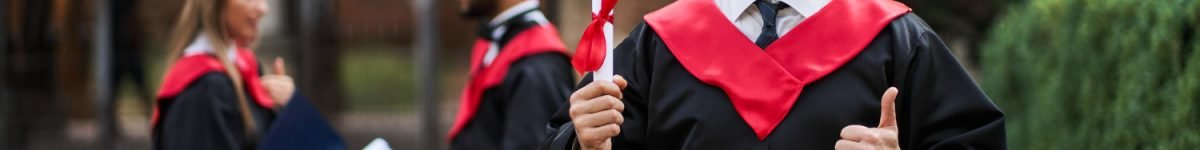 happy-caucasian-graduate-with-his-classmates-graduation-gown-holds-diploma-campus